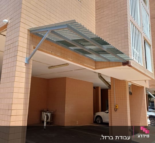 סככה מתכתית מחוברת לקיר בניין